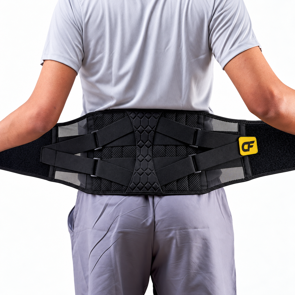 A person viewed from the back wearing a black back support belt with multiple adjustable straps and a yellow logo patch, against a plain white background.